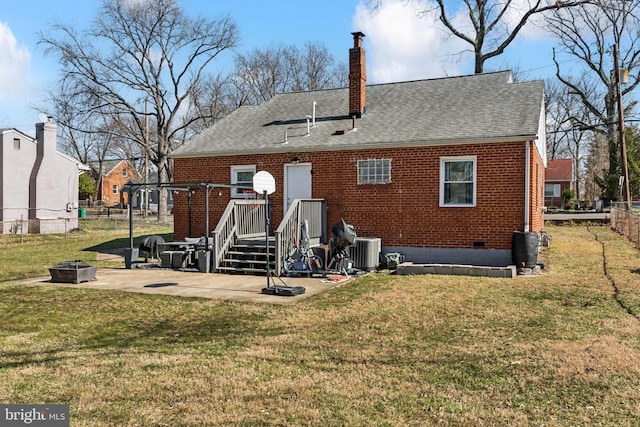 back of house with fence, a fire pit, brick siding, and a lawn