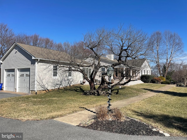 view of front of home with aphalt driveway, a front yard, and a garage