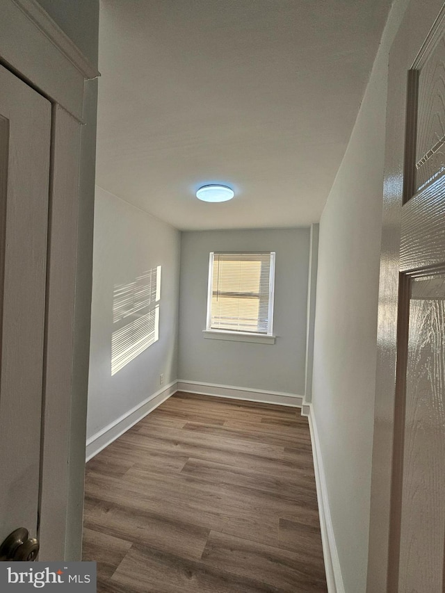 hallway with baseboards and wood finished floors