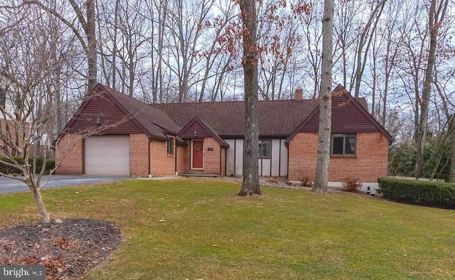 view of front of house with aphalt driveway, brick siding, a garage, and a front yard