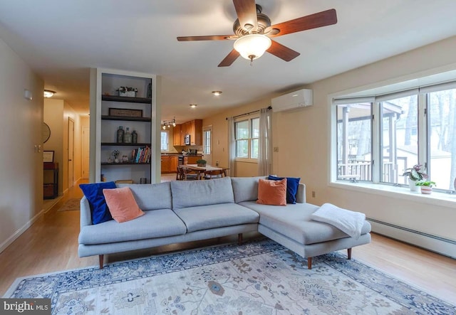 living area with a wall mounted air conditioner, a ceiling fan, a baseboard heating unit, wood finished floors, and baseboards