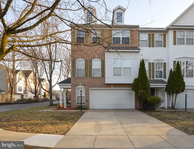 view of property featuring brick siding, an attached garage, and driveway