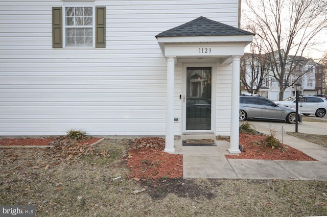 property entrance with a shingled roof