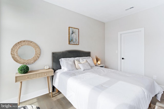 bedroom with baseboards and wood finished floors