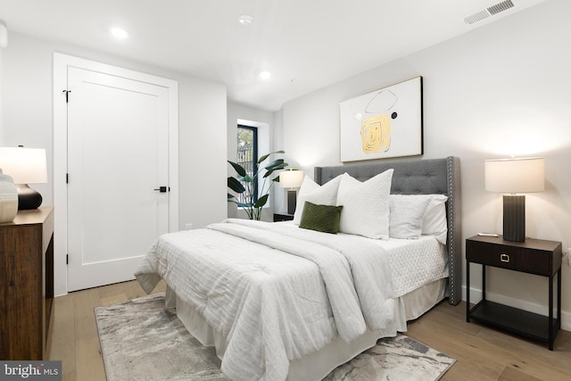 bedroom with recessed lighting, visible vents, baseboards, and light wood finished floors