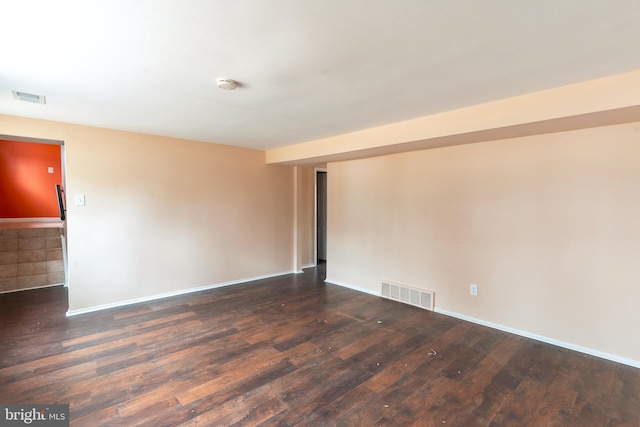 spare room with hardwood / wood-style floors, baseboards, and visible vents