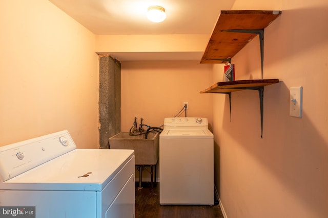 washroom featuring washer and dryer, laundry area, dark wood finished floors, and a sink