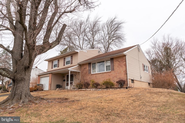 view of front of house with a garage, brick siding, and a front yard