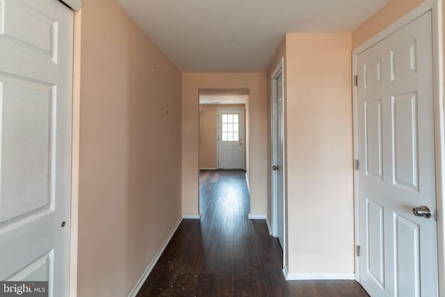 hallway featuring dark wood-style floors and baseboards