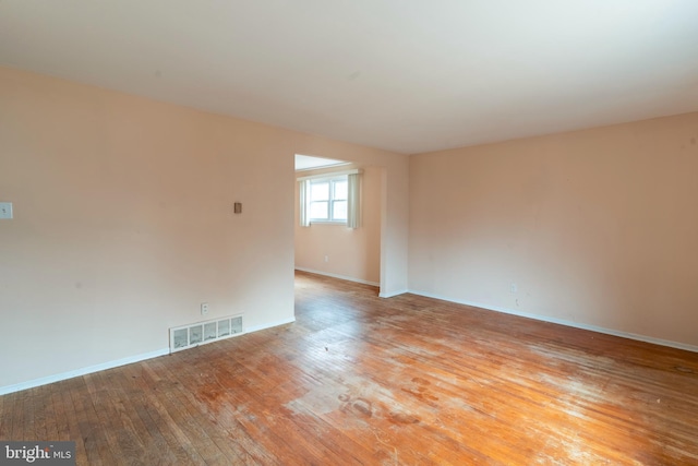 spare room with baseboards, visible vents, and light wood finished floors