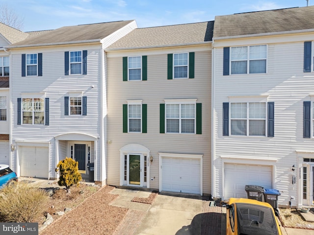 multi unit property featuring a garage and driveway