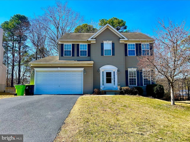 colonial house featuring aphalt driveway, an attached garage, and a front lawn