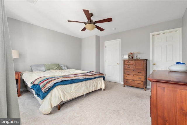 bedroom featuring light colored carpet, baseboards, and ceiling fan