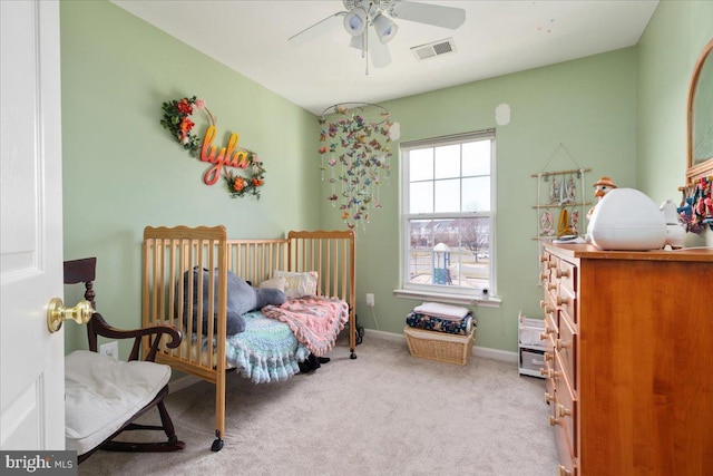 carpeted bedroom with visible vents, baseboards, and a ceiling fan