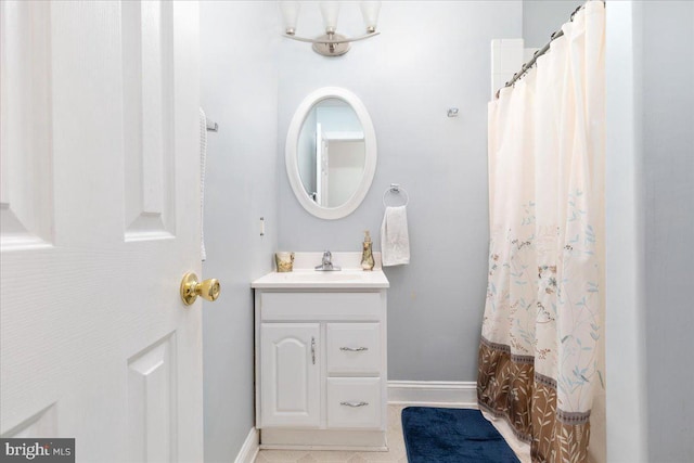 bathroom with vanity, baseboards, and tile patterned flooring