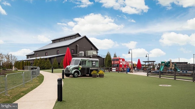 view of home's community featuring playground community and fence