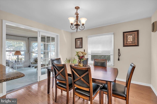 dining room featuring wood finished floors, baseboards, and a chandelier