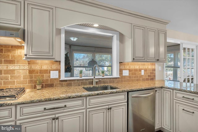 kitchen with a sink, decorative backsplash, plenty of natural light, and stainless steel dishwasher