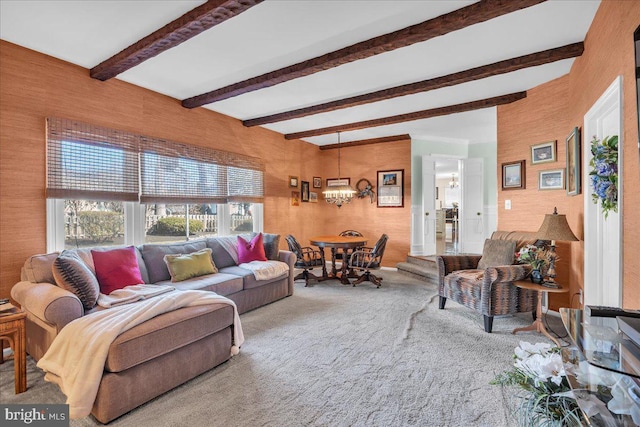 living area with beamed ceiling, carpet, and a chandelier