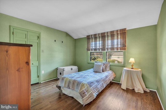 bedroom featuring vaulted ceiling, wood finished floors, and baseboards