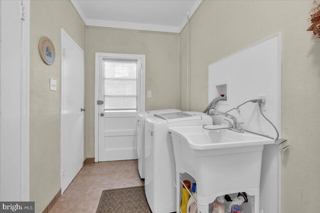 washroom with light tile patterned floors, ornamental molding, laundry area, and washing machine and clothes dryer