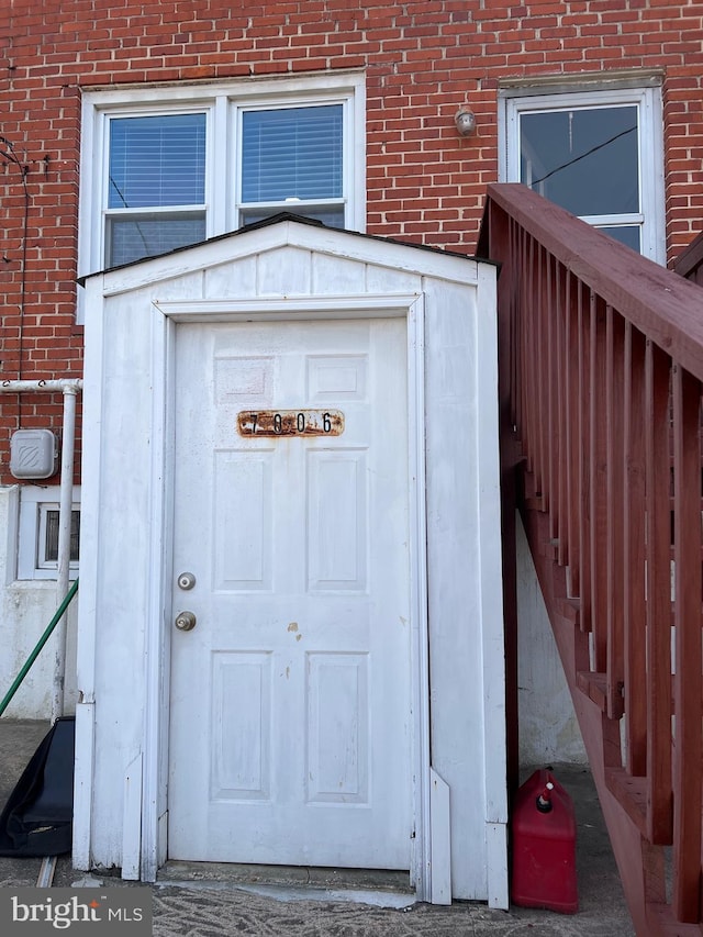 view of exterior entry featuring brick siding