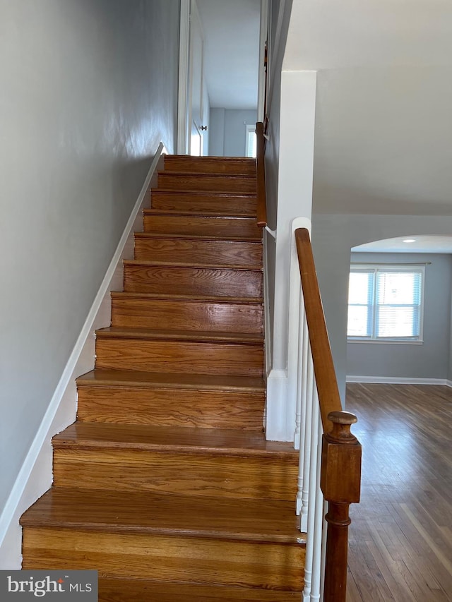 staircase with wood finished floors and baseboards