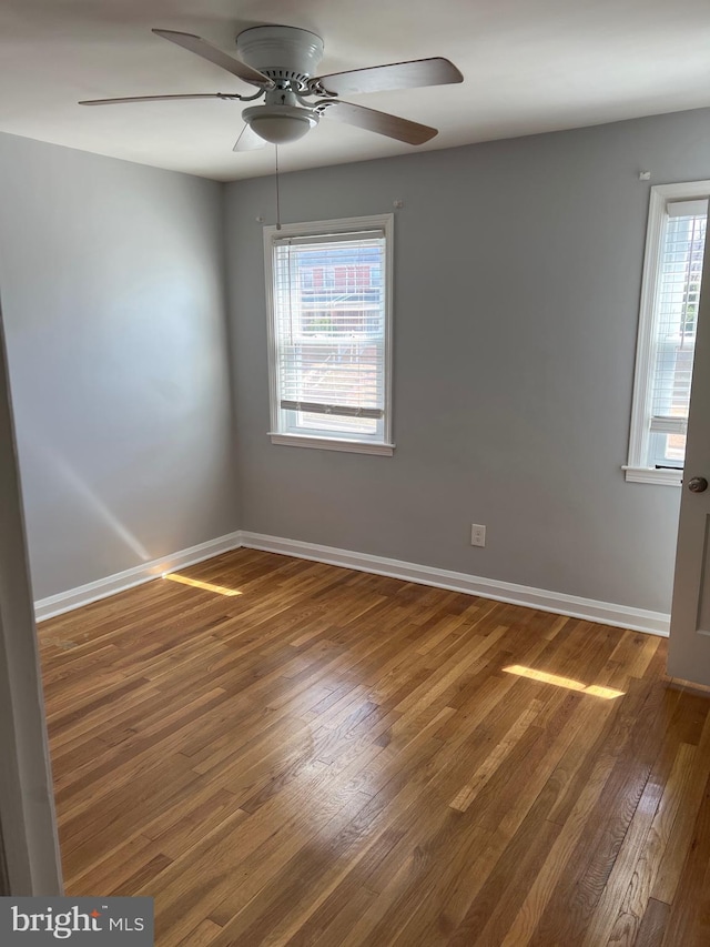 empty room with baseboards and wood finished floors