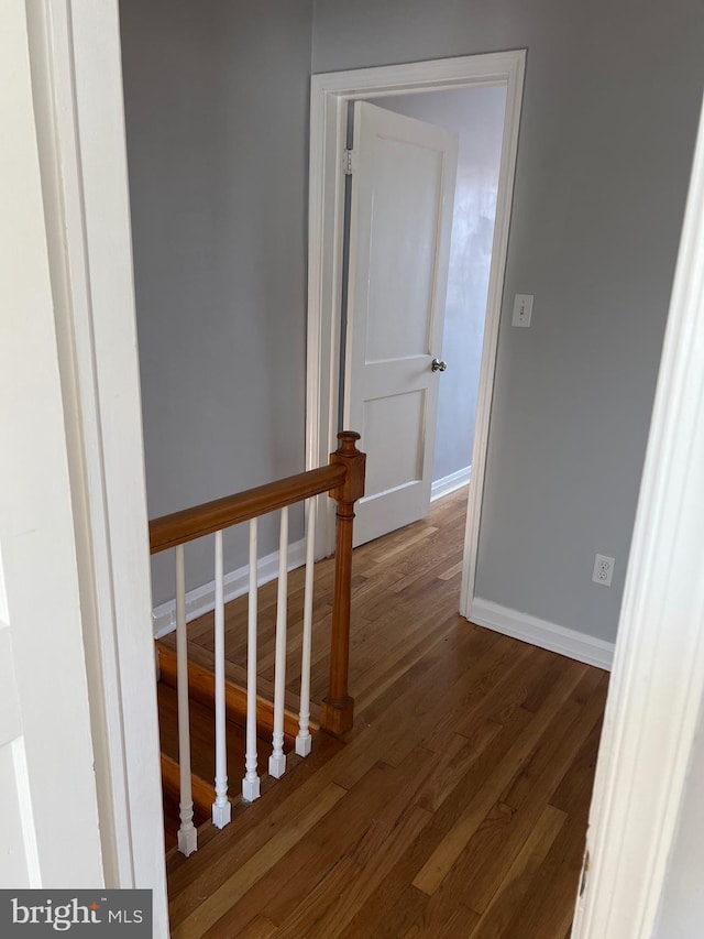 hallway with baseboards and wood finished floors