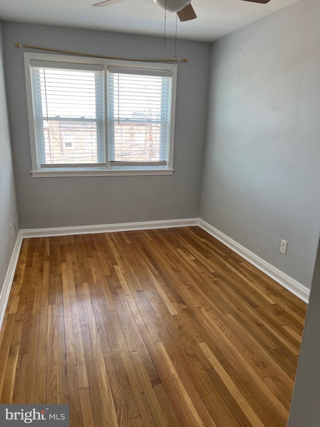 unfurnished room with hardwood / wood-style flooring, a healthy amount of sunlight, baseboards, and ceiling fan