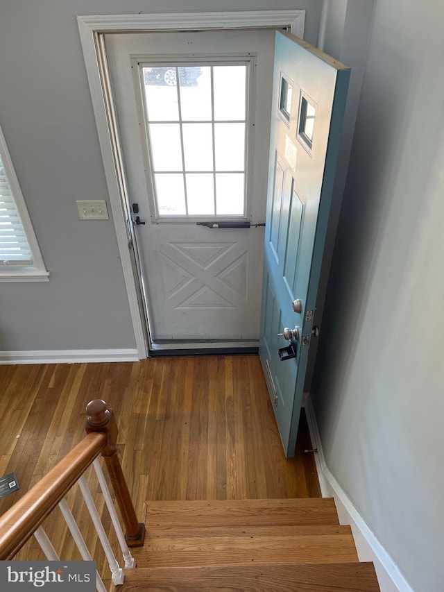 doorway with stairway, baseboards, and wood finished floors