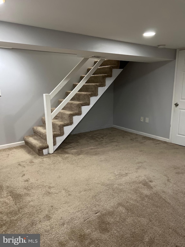 finished below grade area with stairway, baseboards, and carpet flooring