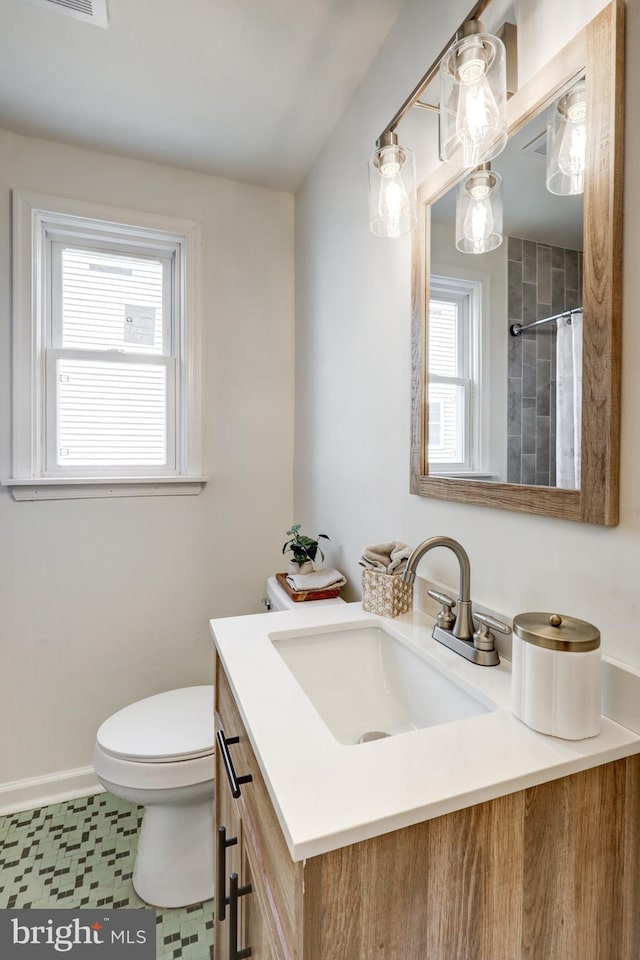 bathroom with baseboards, toilet, vanity, and a shower with curtain