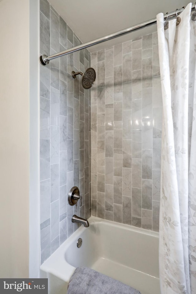 bathroom with shower / bath combo with shower curtain