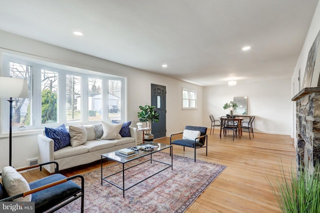 living area featuring recessed lighting, light wood-type flooring, baseboards, and visible vents