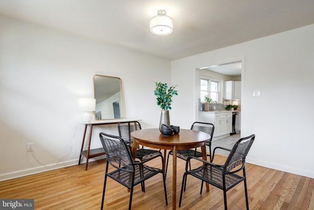 dining area with baseboards and light wood-style floors