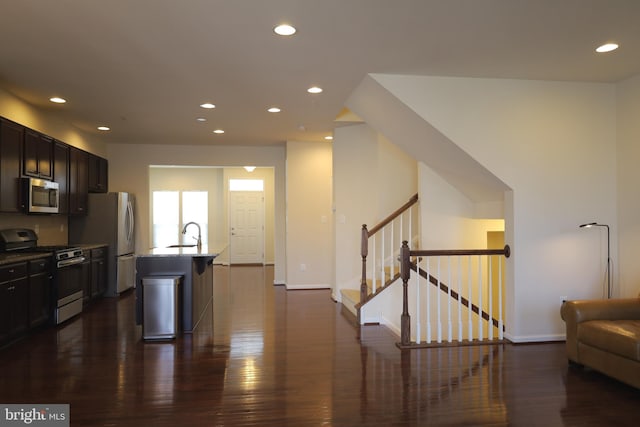 kitchen with dark wood-type flooring, recessed lighting, open floor plan, and appliances with stainless steel finishes