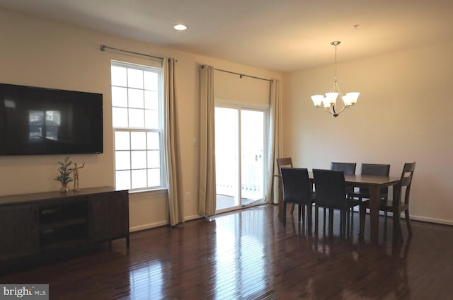 dining area with baseboards, dark wood-type flooring, a healthy amount of sunlight, and a chandelier