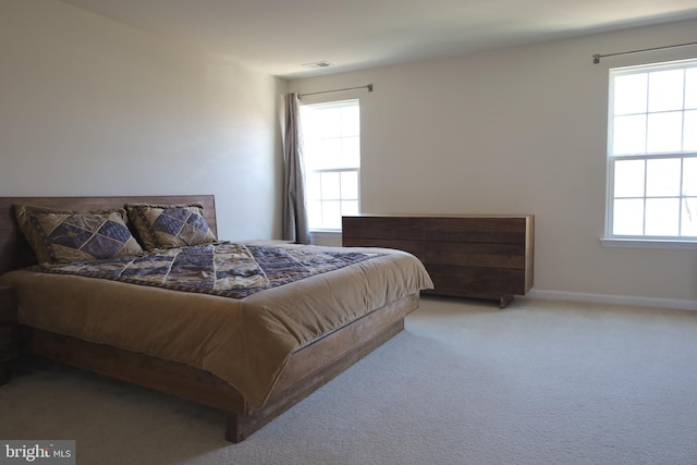 carpeted bedroom with visible vents and baseboards