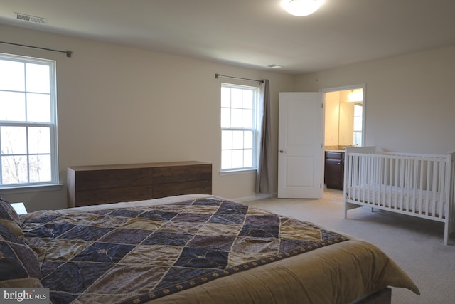 bedroom with light carpet, visible vents, and multiple windows