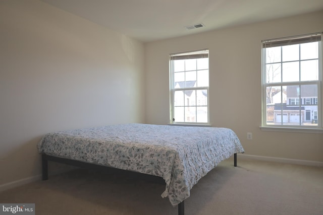 bedroom featuring visible vents, carpet floors, and baseboards