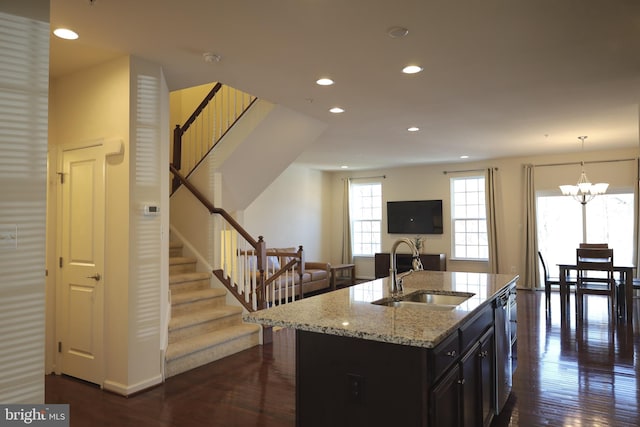 kitchen featuring light stone countertops, open floor plan, recessed lighting, dark wood-style floors, and a sink