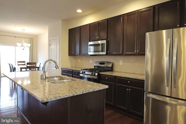 kitchen with dark wood-style flooring, appliances with stainless steel finishes, decorative backsplash, and a sink