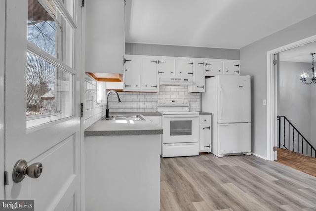 kitchen featuring tasteful backsplash, under cabinet range hood, white appliances, white cabinetry, and a sink