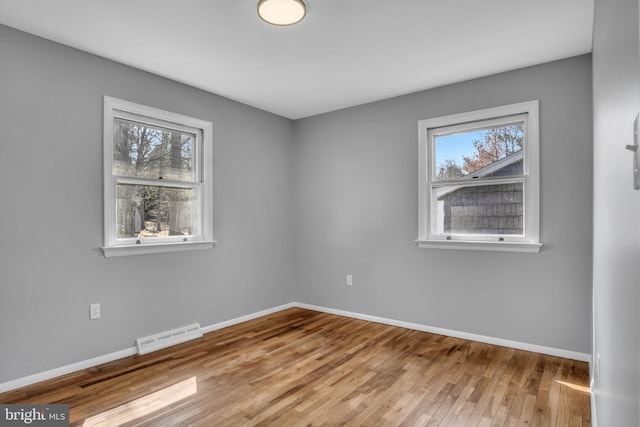 spare room featuring visible vents, a healthy amount of sunlight, and baseboards