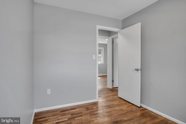 spare room featuring wood finished floors and baseboards