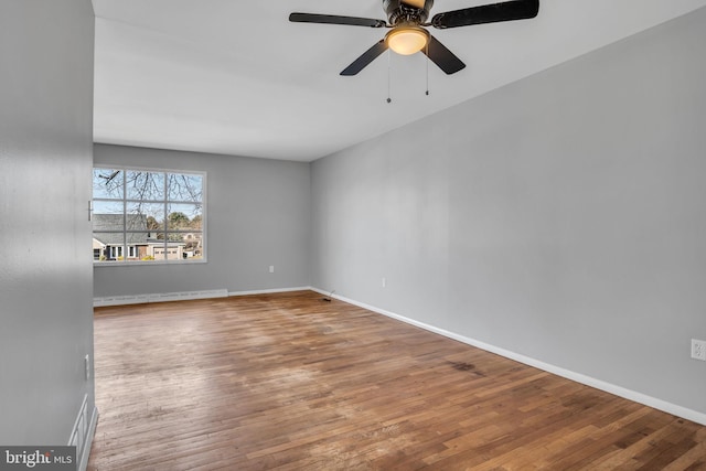 unfurnished room with baseboards, baseboard heating, and wood finished floors