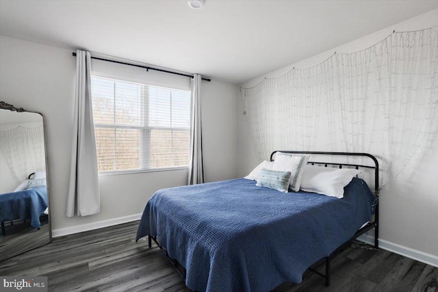 bedroom with lofted ceiling, wood finished floors, and baseboards