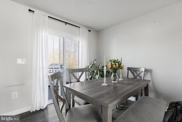 dining space featuring baseboards and dark wood-style floors