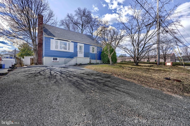 view of front of home featuring driveway and a chimney